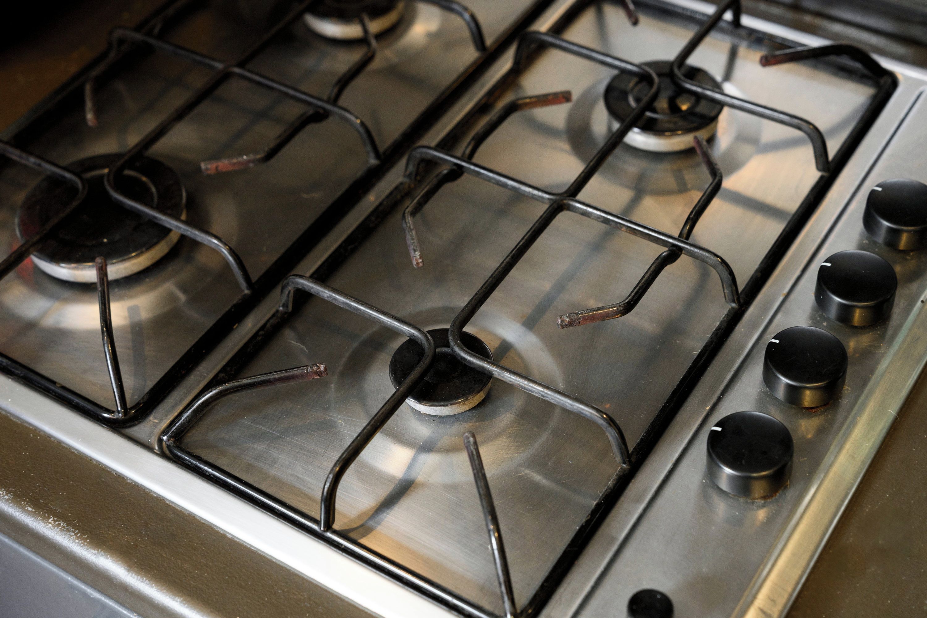 A gas stove with four burners and four knobs.