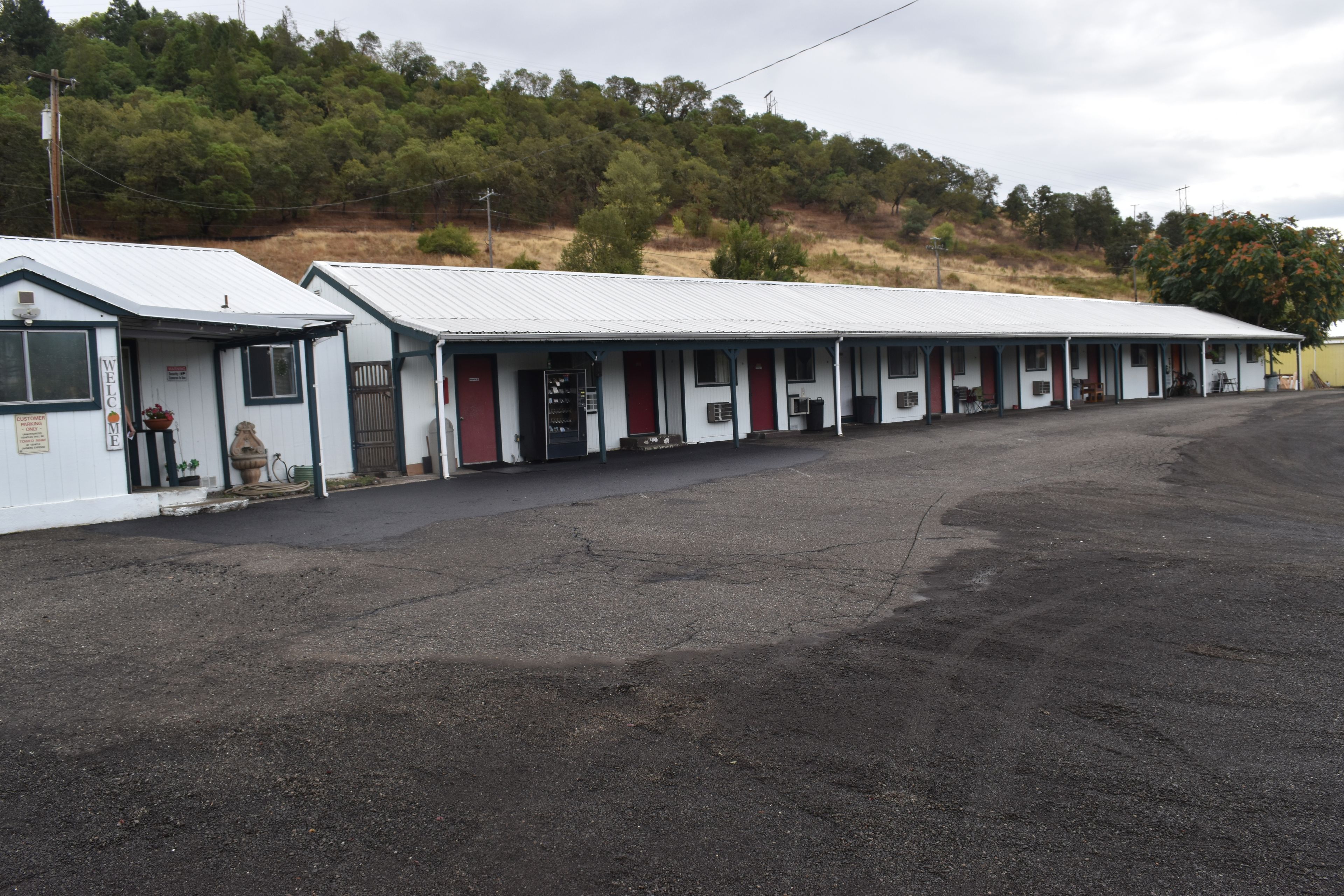 A row of motel-style buildings with a flat roof and a single-story structure.