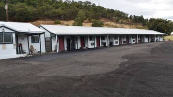 A row of motel-style buildings with a flat roof and a single-story structure.