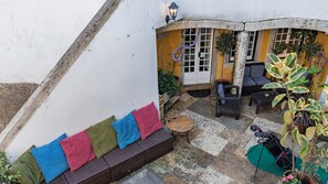 A courtyard with a seating area, a door, and a window. - 17th-century Chapel Smart Home in Historic Sintra (Sintra)