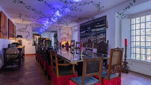 A dining area with a long table, chairs, and candles. - 17th-century Chapel Smart Home in Historic Sintra (Sintra)