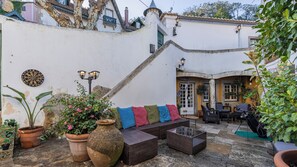 A courtyard with a sofa, potted plants, and outdoor furniture. - 17th-century Chapel Smart Home in Historic Sintra (Sintra)