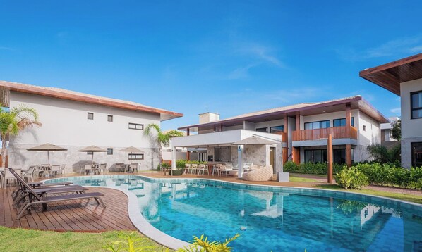 A modern hotel with a swimming pool, outdoor seating, and a well-maintained garden. - Apt. in Condo. w/ Pool & Pool View Vii0001 (Camaçari)