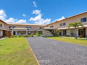 A modern residential complex with multiple houses, a central gravel pathway, and well-maintained lawns. - House in Condo. w/ Pool Vri0003 (Mata de São João)