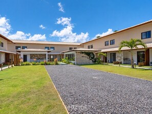 A modern residential complex with multiple houses, a central gravel pathway, and well-maintained lawns.