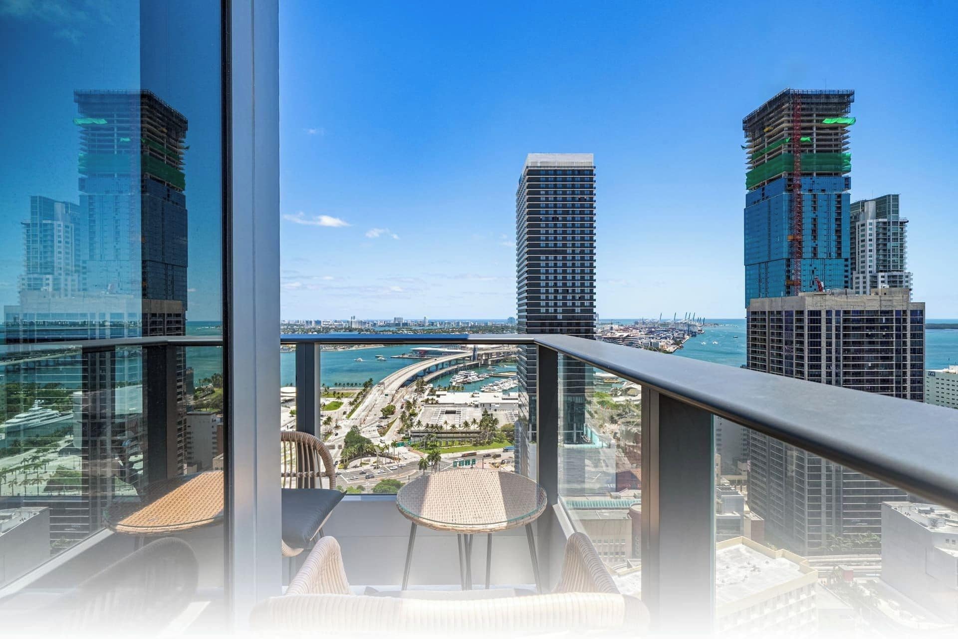 A high-rise building with a view of a marina and cityscape.