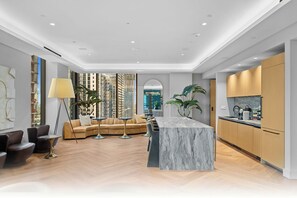 A modern kitchen with marble countertops, wooden cabinets, and a central island.