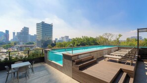 A rooftop pool area with a cityscape view, including a tall building with a DWC logo. - New Listing (Guadalajara)