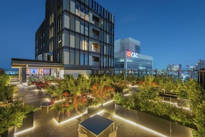 A rooftop terrace with outdoor seating and a view of a city skyline at dusk. - New Listing (Guadalajara)