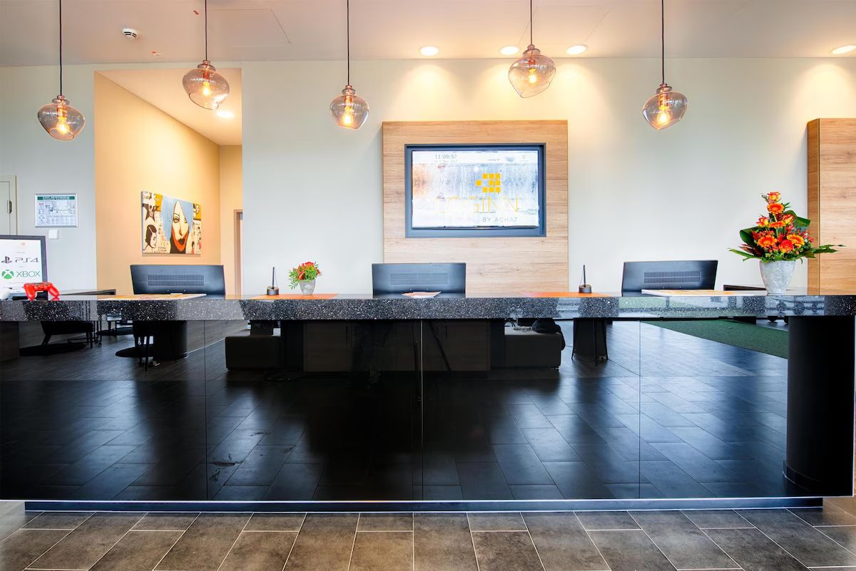 Check in quickly at the minimalist desk under soft lighting.