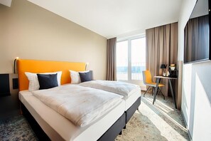 Ein Hotelzimmer mit einem großen Bett, einem Schreibtisch und einem Stuhl.