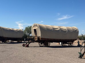 Two covered wagons with a small door and steps, parked on a gravel surface. - Wagon 5 Cozy 1-bedroom recreational vehicle with AC in terrific Casa Grande (Casa Grande)