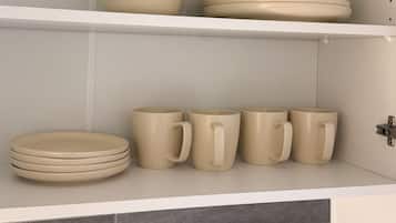Uma cozinha com armários brancos e azulejos cinzas.