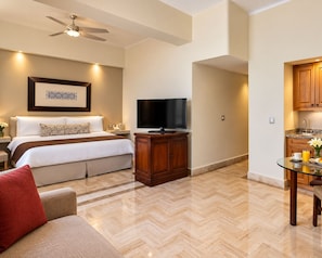 A hotel room with a bed, a television, a wooden cabinet, a dining table with a glass top, and a ceiling fan. - Luxury 1 Bedroom Getaway at Club Velas Vallarta, All Inclusive Mexico Paradise (Puerto Vallarta)