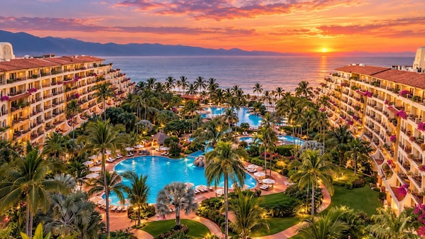 A resort with multiple swimming pools, palm trees, and a sunset view. - Luxury 1 Bedroom Getaway at Club Velas Vallarta, All Inclusive Mexico Paradise (Puerto Vallarta)