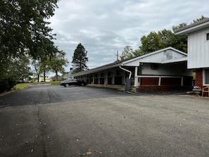 A motel with a row of rooms, a covered parking area, and a building with a garage.