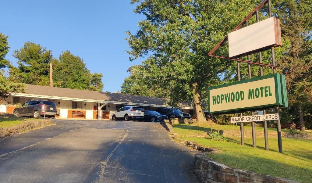 Um motel com uma placa indicando 'Hopwood Motel' e um aviso sobre 'CARTÕES DE CRÉDITO ACEITOS'.