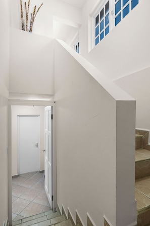 A white interior with a staircase leading to a door. - Palma Real 29 - your vacation Condo in Palm Beach (Palma Real)