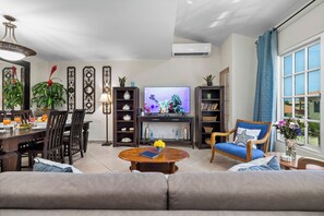 A living room with a sofa, coffee table, TV, and decorative items. - Palma Real 29 - your vacation Condo in Palm Beach (Palma Real)