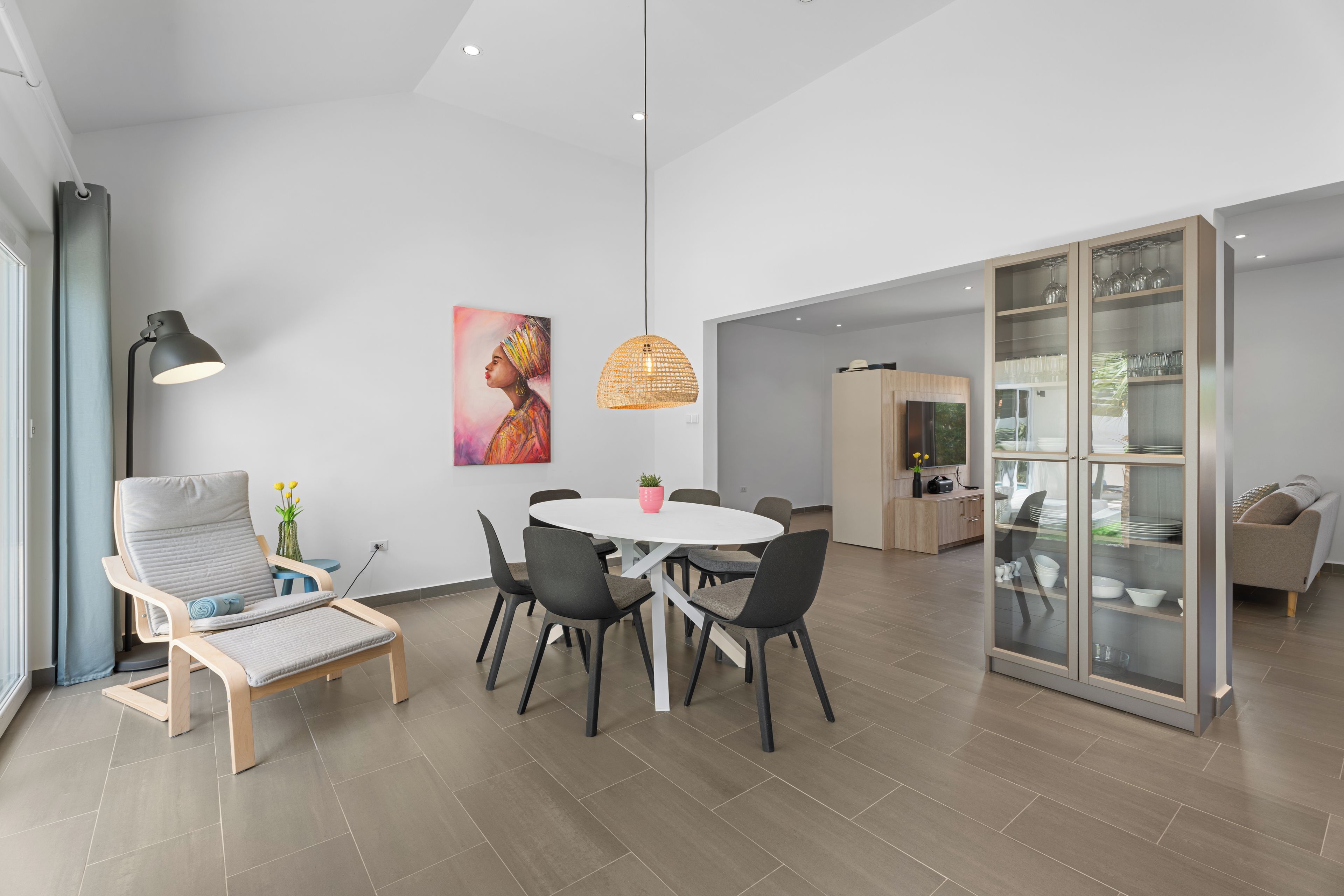 A modern dining area with a round table, chairs, and a pendant light. - Modern Three Bedroom Villa in Noord (Boegoeroei)