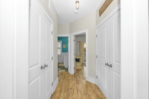 A hallway with white doors, a ceiling light, and a laundry room sign. - OIB Waterfront Retreat w/ Dock & Golf Cart 5BR (Ocean Isle Beach)