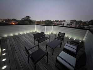 A rooftop deck with outdoor furniture and string lights. - Luxurious 3BR @ H St Corridor Free Cancellation (Washington)