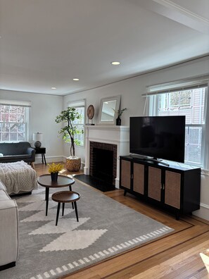 A modern living room with a fireplace, television, and seating area. - 4-bedroom Eastside single home with cool AC for relaxing stay (Providence)