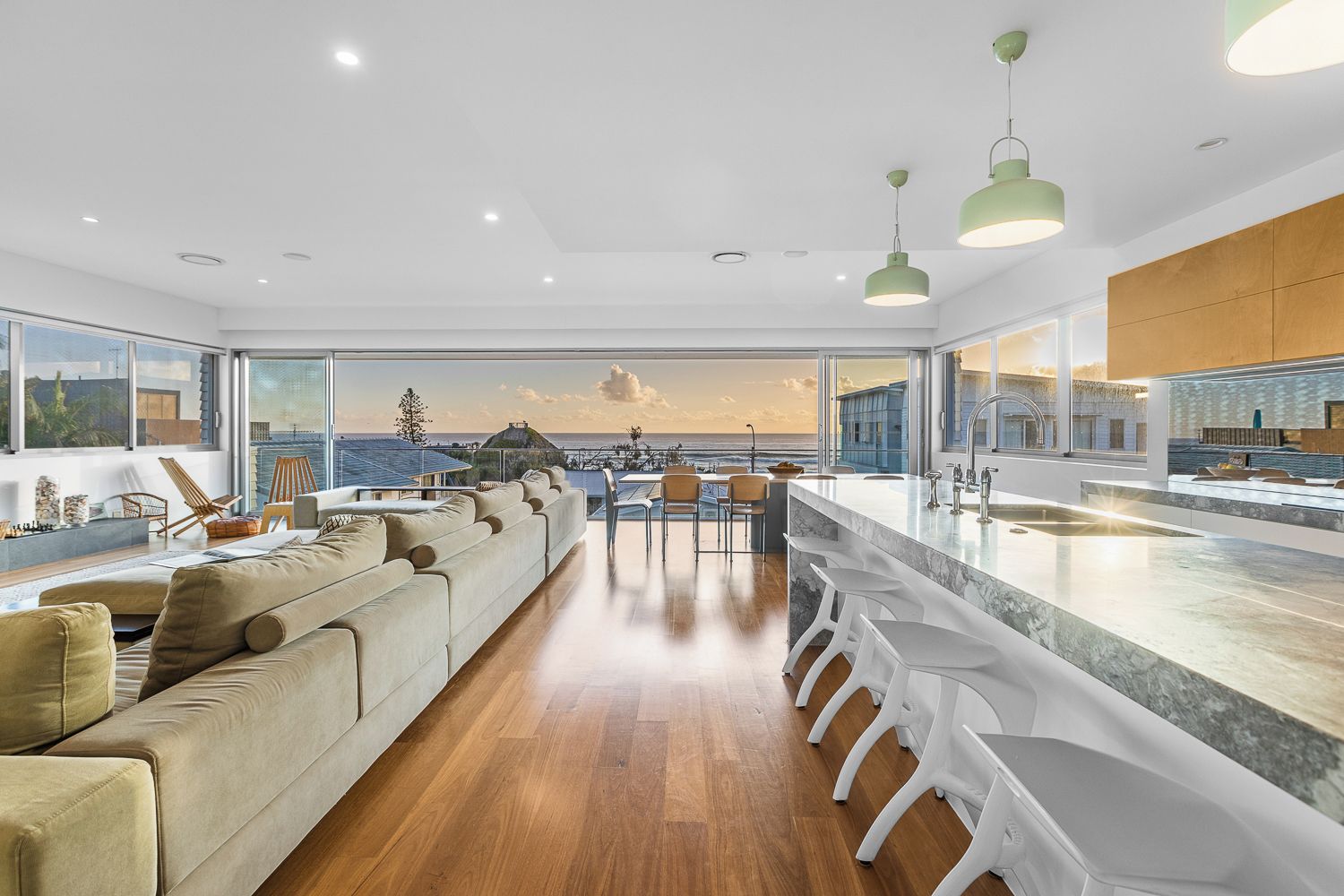 Een moderne keuken met een groot kookeiland, een bargedeelte en uitzicht op zee.
