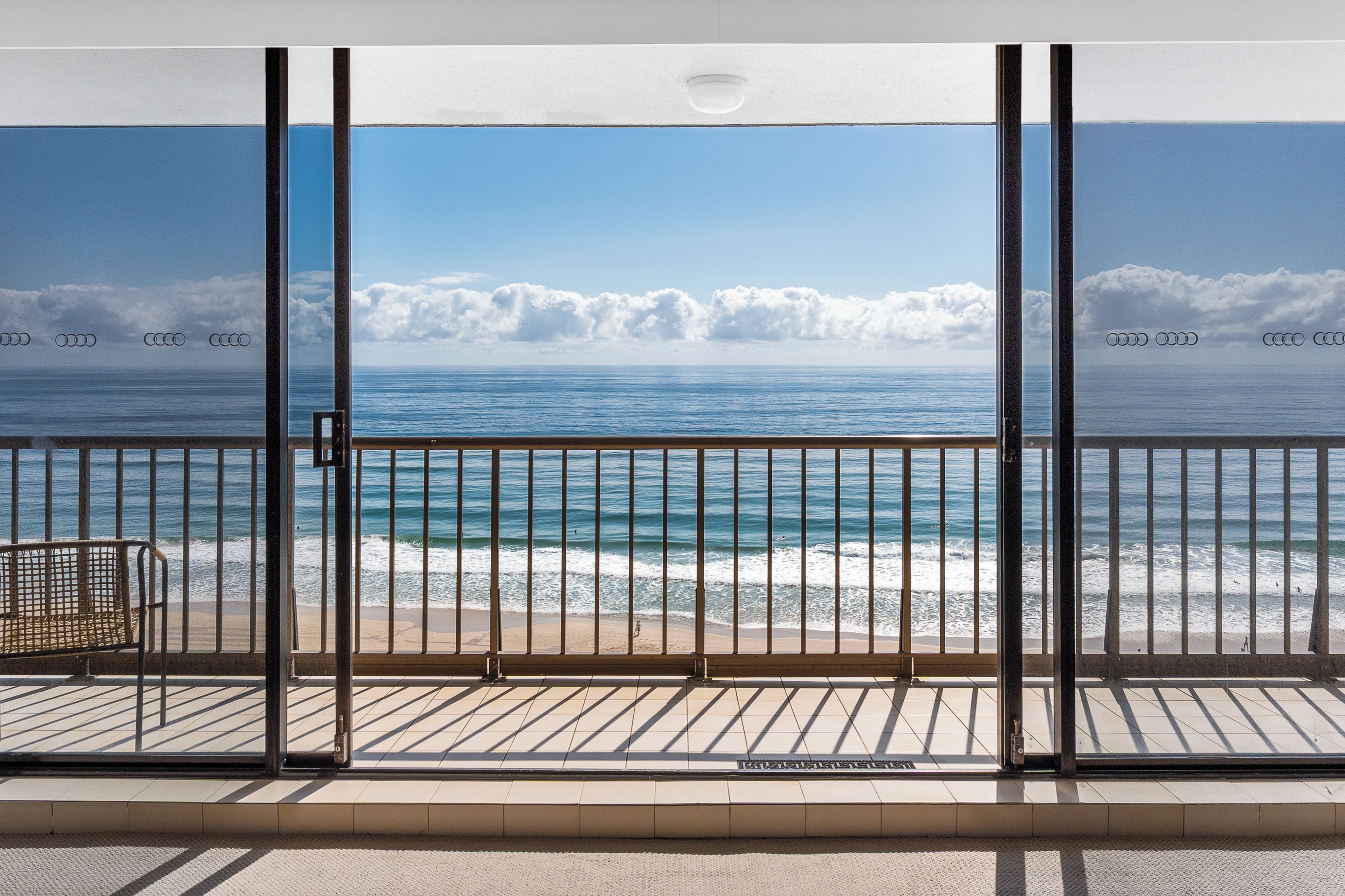 Een balkon met uitzicht op zee en strand.