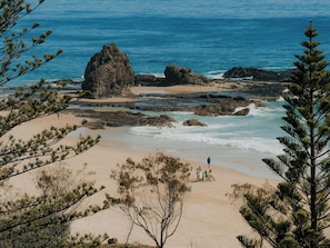 A coastal landscape with a sandy beach, rocky outcrops, and sparse vegetation. - The Rocks 11H Currumbin Escape with Ocean Views (Currumbin)
