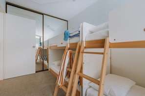 A room with bunk beds, a mirror, and a door leading to another room. - The Rocks Resort GI Currumbin Escape (Currumbin)