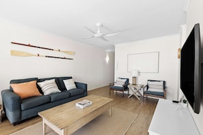 A modern living room with a sofa, coffee table, and two armchairs. - Surfside 8 with direct beach access. (Palm Beach)