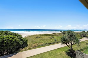 A coastal view with a beach, a clear sky, and a pathway leading to the beach. - Surfside 8 with direct beach access. (Palm Beach)