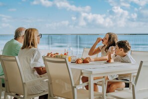 A family dining at a table with a view of the sea. - Joy on Jefferson Stunning Palm Beach Escape (Palm Beach)