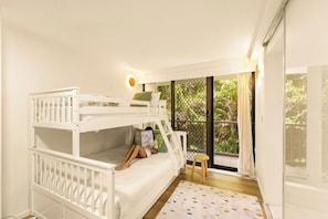 A bunk bed room with a view of greenery through a window. - The Rocks Resort 4C Currumbin Beachfront Apartment (Currumbin)