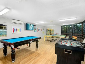 A room with a pool table, foosball table, and various wall decorations. - The Rocks Resort 4C Currumbin Beachfront Apartment (Currumbin)