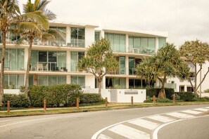 Un immeuble à plusieurs étages doté d’une architecture moderne, caractérisé par de grandes fenêtres et un toit plat.