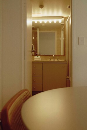 Een badkamer met spiegel, wastafel en handdoekhouder.
