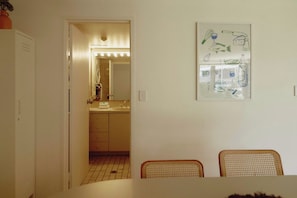 A room with a dining table, chairs, a mirror, and a wall with a framed drawing. - Golden Era - Tugun Beachfront (Tugun)