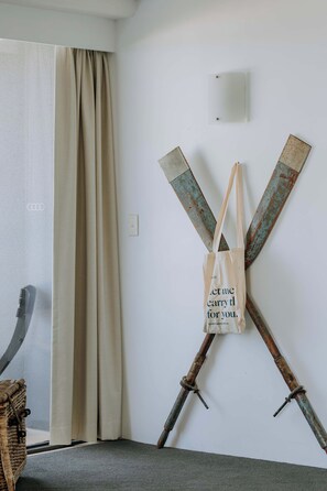 A room with a beige curtain, a wall-mounted light, and a rustic metal sculpture. - The Rocks Resort 5D with Ocean View (Currumbin)
