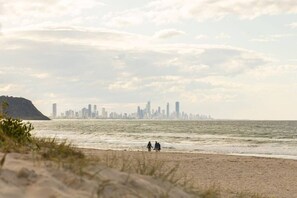 Ein Strand mit einer Stadtansicht im Hintergrund.