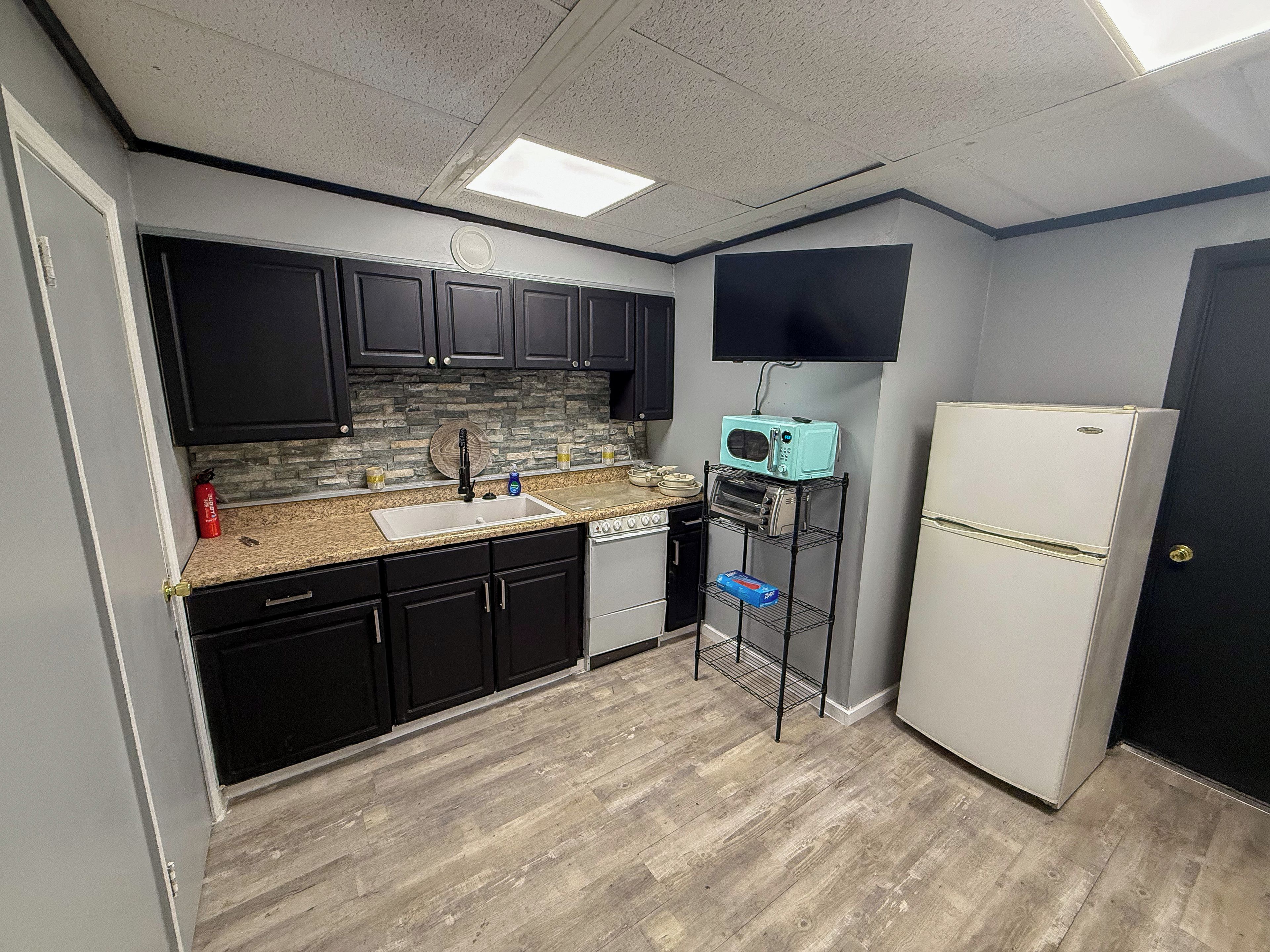 A compact kitchen with a microwave, toaster oven, and refrigerator.