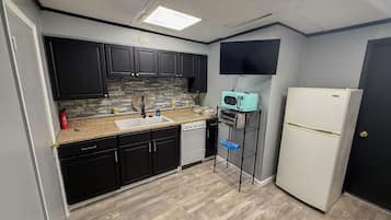 A compact kitchen with a microwave, toaster oven, and refrigerator.