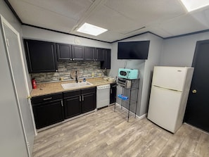 A compact kitchen with a microwave, toaster oven, and refrigerator.