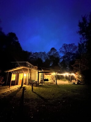 Ein Haus mit einer Veranda, einem überdachten Bereich und einem Garten.
