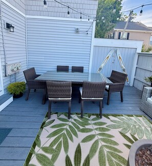 A patio with a table and chairs, a decorative rug, and a fence. - Spacious 6-bedroom, 2 Kitchen, 3 bath house in tranquil Old Orchard Beach (Old Orchard Beach)