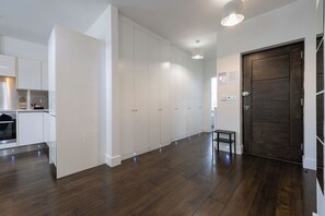 A modern kitchen with white cabinetry and a dark wood floor. - Contemporary 3BR | Near City Centre | FREE Parking (Reading)
