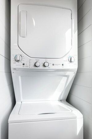 A front view of a white washing machine with control knobs and a digital display. - 1BR Fredericksburg retreat with hot tub, fire pit, grill (Fredericksburg)