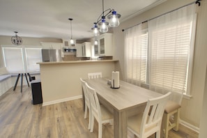 A modern kitchen with white cabinetry, a central island, and pendant lighting. - Indy Gameday House - Downtown - 10 Walk to Lucas Oil Stadium (Indianapolis)