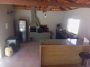 Una cocina compacta con horno integrado, refrigerador y encimera de madera.